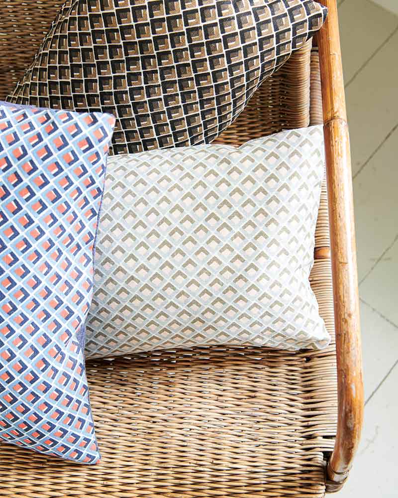 Patterned pillows in a rattan chair.