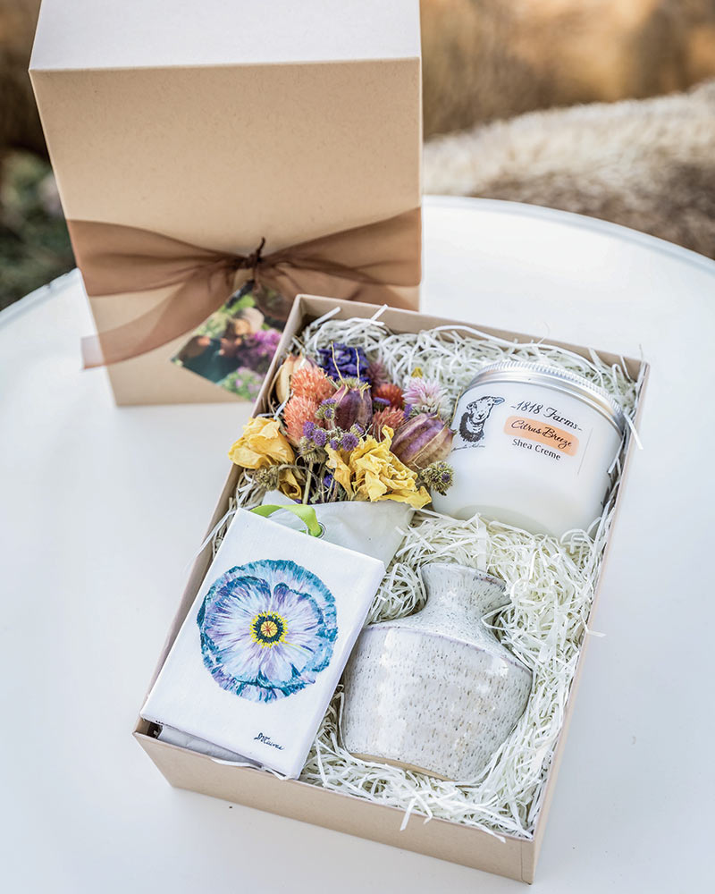 A box filled with dried florals, soap, and lotion. 