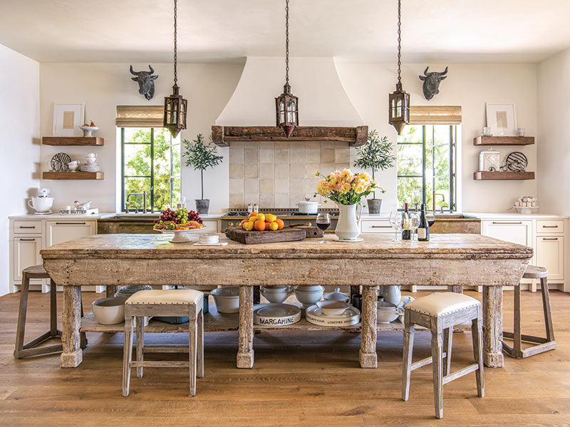 A rustic kitchen with an antique sculptor's table repurposed as an island.