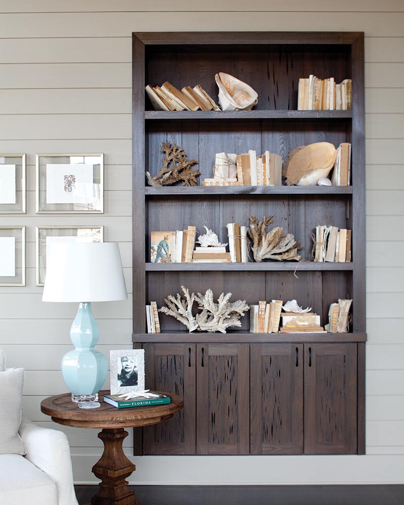 A built-in bookshelf with coral pieces.