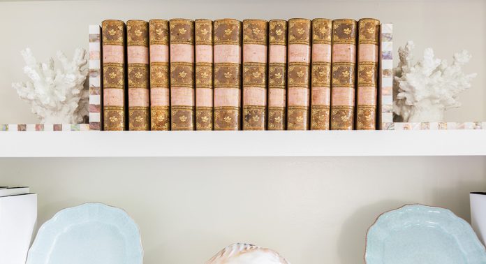 A bookshelf with white coral-shaped bookends.