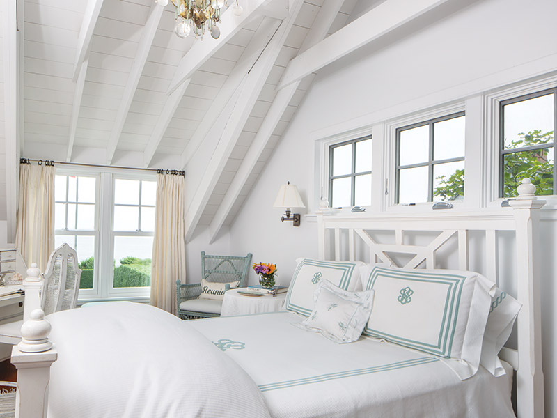 A white bedroom with blue-and-white linens.