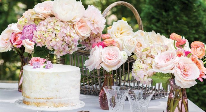 A romantic style tablescape with pink blooms and a simple cake.