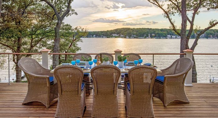 An outdoor dining area on a deck overlooking the lake.