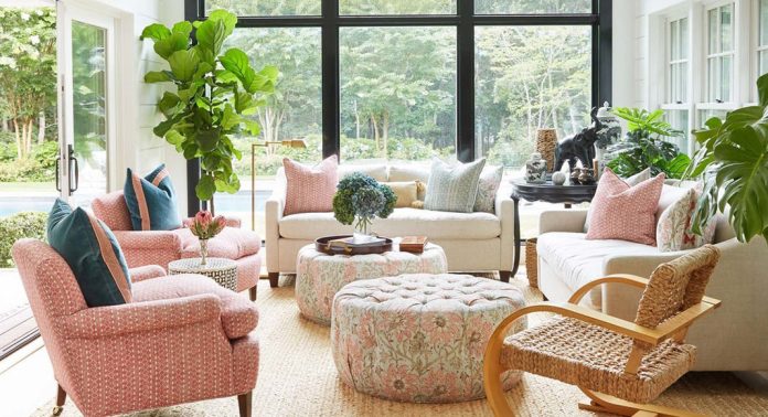 A sunroom with blush and white furniture.