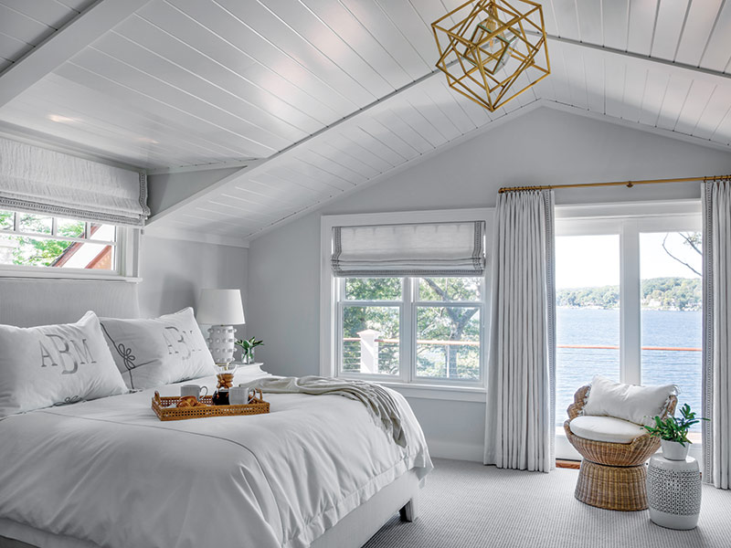 A white bedroom with rattan accents. 