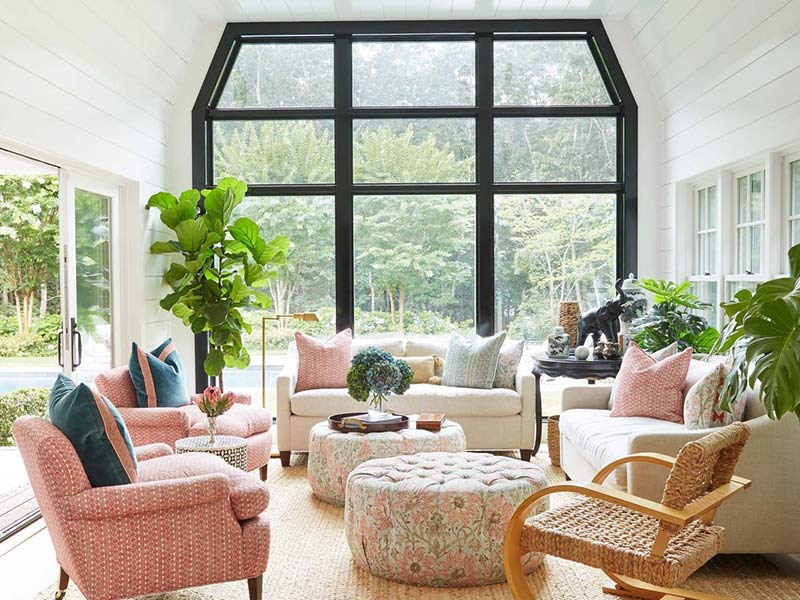 A white sunroom with blush furnishings.