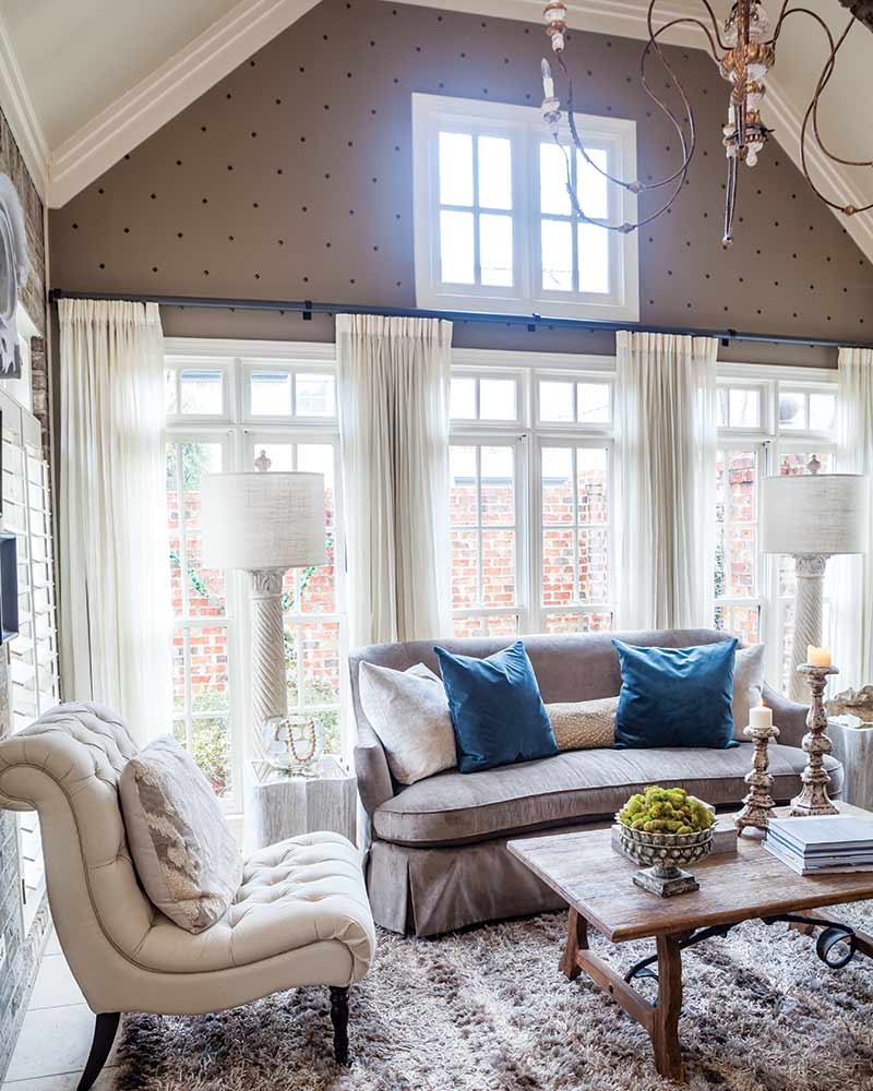 A neutral sunroom with nailhead embellished walls.