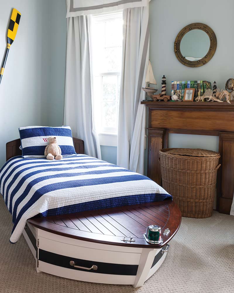 A nautical-themed kids room with a boat-shaped bed.