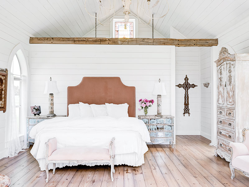 A bedroom with white walls and furnishings.
