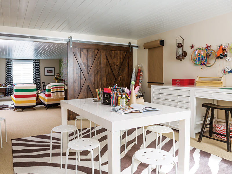 A media room with a craft table and sliding barn door.