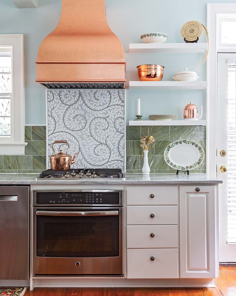 South Carolina Home - kitchen with gas stove, green backsplash, copper hood vent