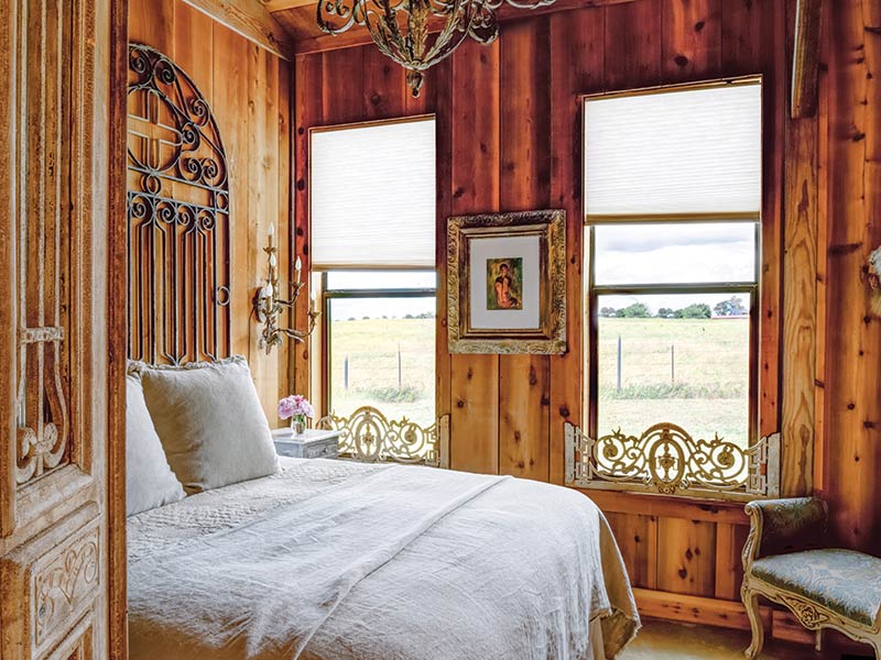 A bedroom with wood paneling and white furnishings.