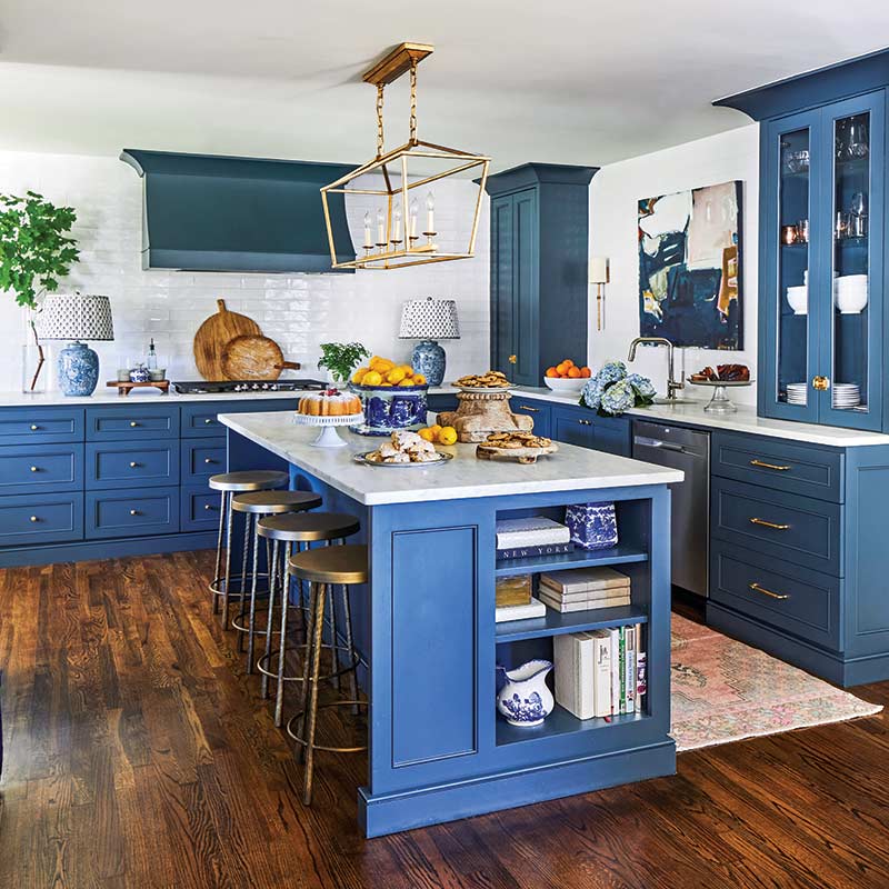 A kitchen with blue cabinets and white countertops.